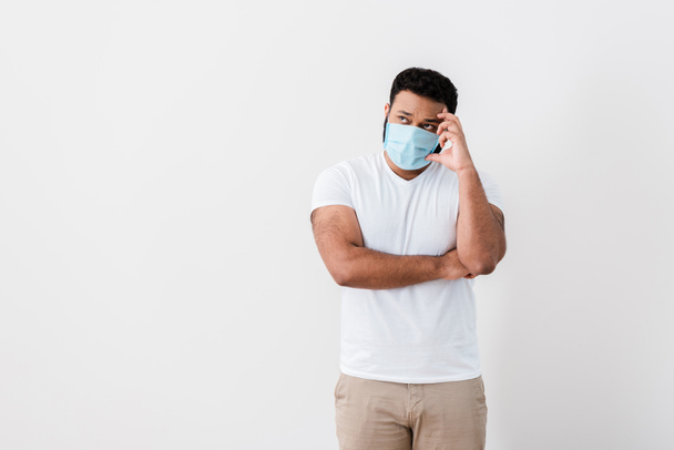 pensive african american man in medical mask standing near white wall  - Foto, Imagen