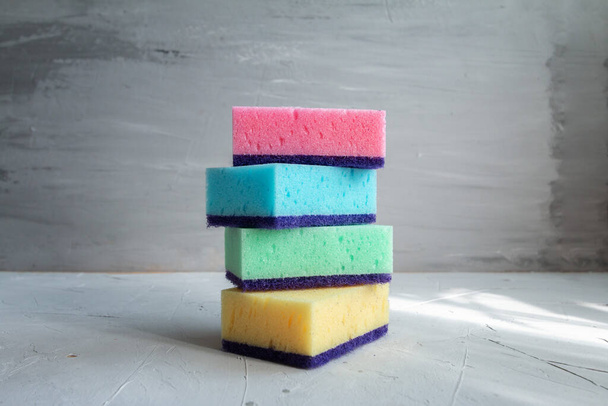 pilha de esponjas coloridas para lavar pratos contra fundo cinza
 - Foto, Imagem