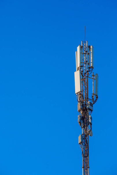 Antena de comunicações móveis contra um céu azul
 - Foto, Imagem