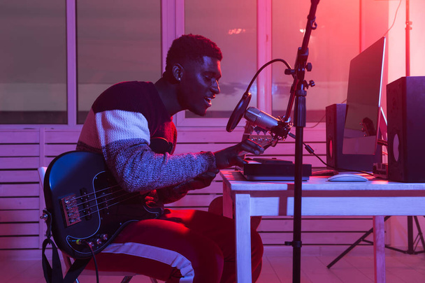 Δημιουργία μουσικής και μια έννοια στούντιο ηχογράφησης - αφροαμερικανός άνθρωπος ηχογράφηση synthesizer κομμάτι στο στούντιο σπίτι - Φωτογραφία, εικόνα