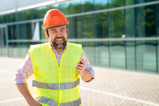 férfi az építőiparban sisak válaszol telefon hívás - Fotó, kép