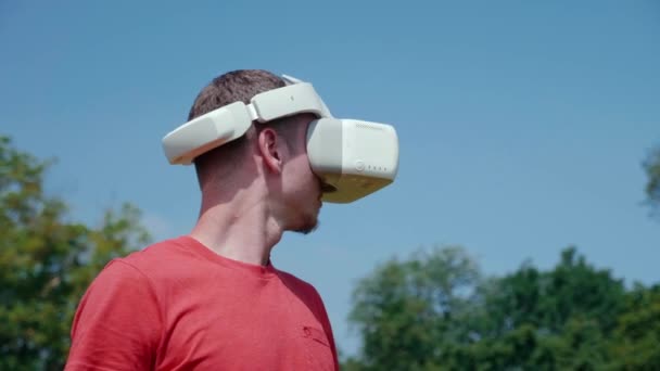 Mann mit Virtual-Reality-Helm dreht den Kopf nach links - Filmmaterial, Video