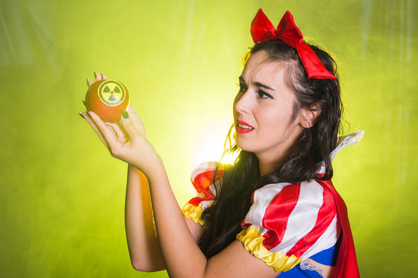 Woman holding hazardous radioactive apple. Nuclear and radiation measurement concept. - Photo, Image
