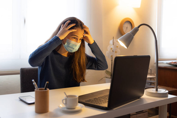 adolescent étudiant avec mains sur la tête se plaint de migraine avec ordinateur à la maison
 - Photo, image
