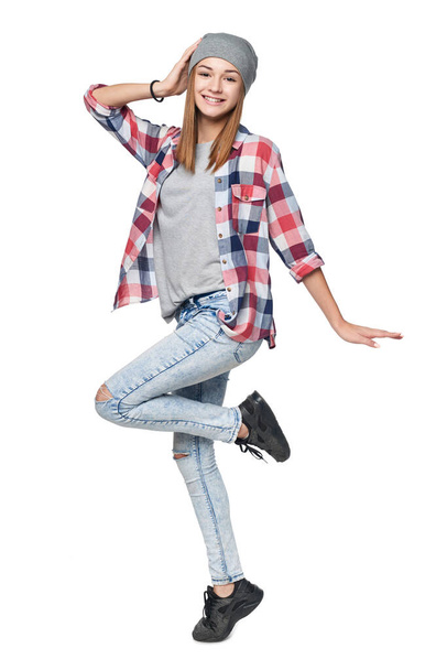 Happy teen girl in full length jumping rejoicing, looking at camera, isolated on white - 写真・画像