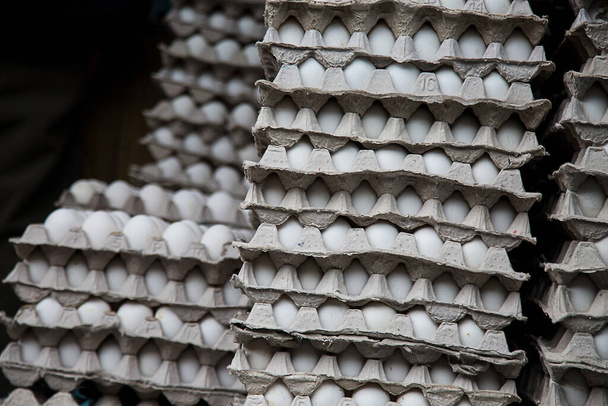 Φρέσκα άσπρα αυγά φάρμας στοιβαγμένα σε δίσκους για χονδρική πώληση στο σούπερ μάρκετ, έτοιμα για αποστολή - Image - Φωτογραφία, εικόνα