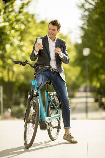Jóképű fiatal üzletember a motorkerékpáron, hogy szelfi fénykép mobiltelefonnal - Fotó, kép