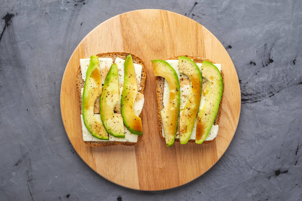 Healthy vegetarian sandwiches with sliced avocado and tofu cheese. Modern and simple Breakfast for every day. Top view - Φωτογραφία, εικόνα