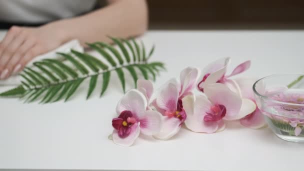 Girl looks at manicure on flower background - Footage, Video