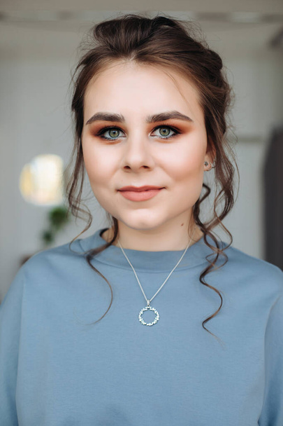 portrait of a beautiful girl with collected hairstyle and gentle makeup. Beauty face. Blue blouse. Color type. looking at the camera - Valokuva, kuva
