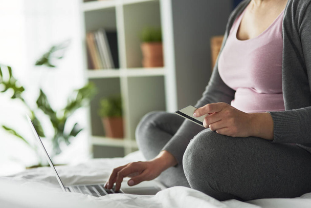 妊娠中の女性のオンラインショッピングの画像を閉じる - 写真・画像