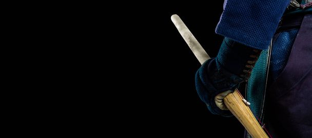 Luchador Kendo con espada de bambú. Grabado en el estudio. Aislado con ruta de recorte sobre fondo negro. Imagen panorámica
. - Foto, imagen