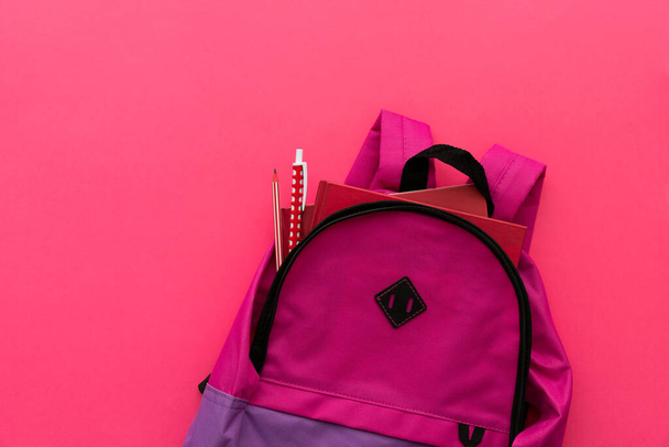 Back to school concept. Backpack with school supplies on pink background. Top view. Copy space - Фото, зображення