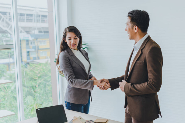 Asian businessmen can make business deals with young businessmen. Both therefore join hands to congratulate them on achieving a business deal. - 写真・画像