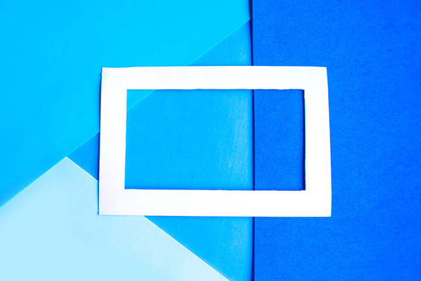 Cadre photo blanc sur fond bleu géométrique. Espace de copie pour le texte. Concept de conception
 - Photo, image