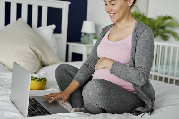 Веселая беременная женщина за компьютером
 - Фото, изображение
