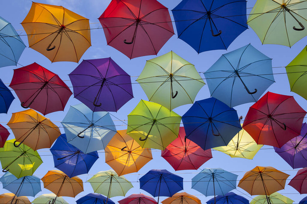 Bunte Regenschirme im Hintergrund. Bunte Regenschirme am Himmel. Straßendekoration. - Foto, Bild