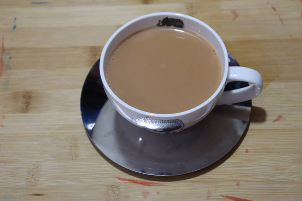 Masala Tea Chai forró egy díszes arany csésze és csészealj fehér alapon - Fotó, kép