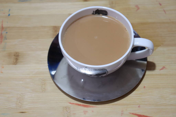 Masala Tea Chai forró egy díszes arany csésze és csészealj fehér alapon - Fotó, kép