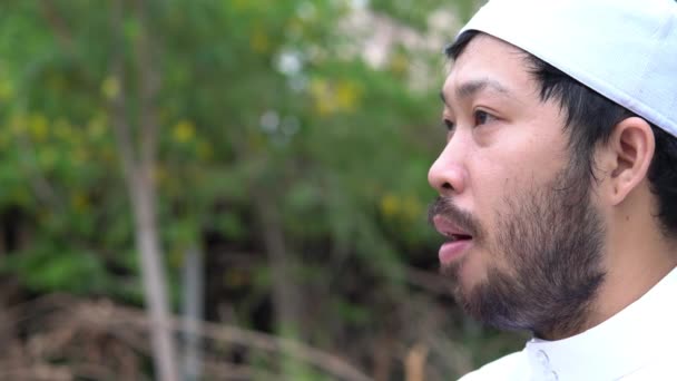 Young Asian muslim man praying outdoors at daytime, Ramadan festival concept - Filmmaterial, Video