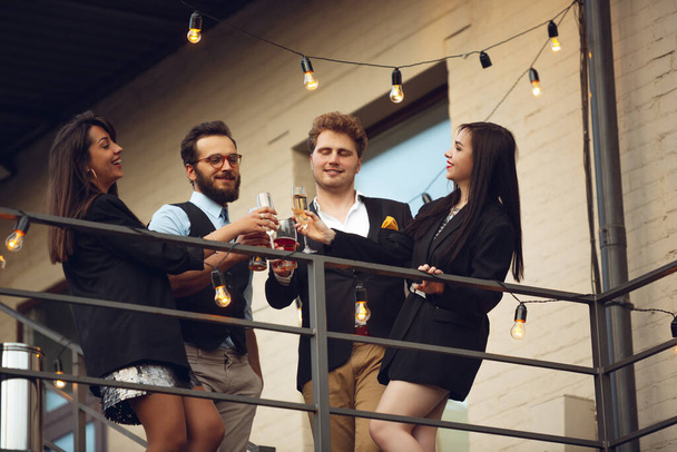 Group of young caucasian people celebrating, look happy, have corporate party at office or bar - Foto, afbeelding