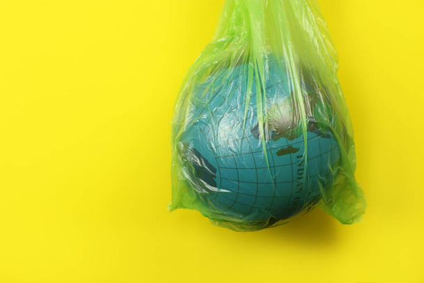 Globe in a plastic garbage bag. Concept of an environmental disaster on the planet. Copy space for your text - Foto, Imagen