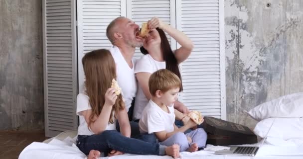 A família em casa em auto-isolamento comer pizza e assistir desenhos animados em um laptop
 - Filmagem, Vídeo