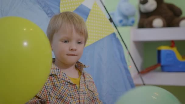 діти вдома, приваблива чарівна чоловіча дитина грає з кольоровими повітряними кулями
 - Кадри, відео