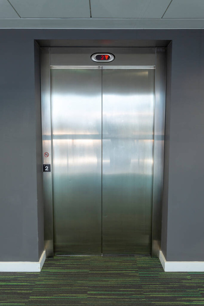 Moderno ascensor con puertas cerradas en un edificio de oficinas
. - Foto, imagen