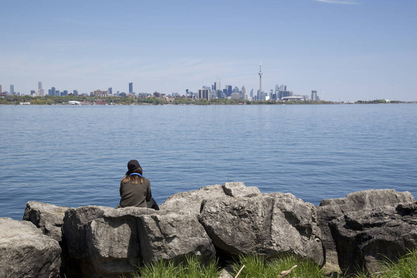 single sitting on the park bench with Toronto cityscape as a background - Photo, Image