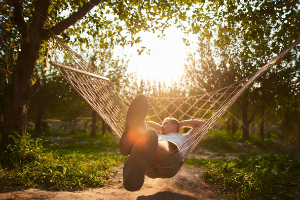 verschwommen und defokussiert sich entspannend in der Hängematte. Der Mensch ruht im Garten. Sommerstimmung im Wald - Foto, Bild