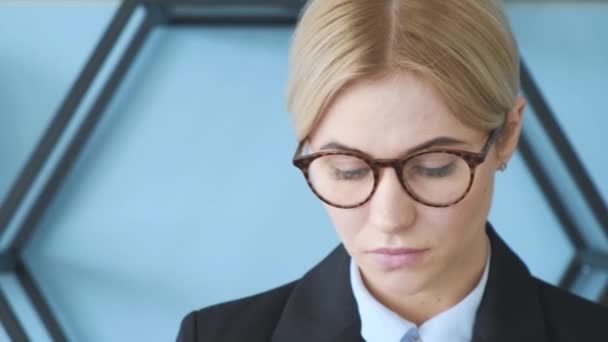 Confident face in glasses of business girl posing at office. Medium close up shot on 4k - Materiał filmowy, wideo