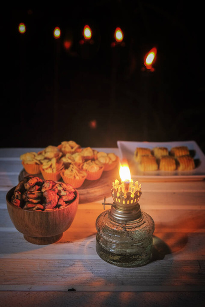 Perinteisen välipalan lähikuva Hari Raya Aidilfitrin aikana Malesiassa nimeltään kuih-torttu tai ananastorttu, cashewpähkinät ja hunajahiutaleet vintage-öljylampulla yöllä
. - Valokuva, kuva