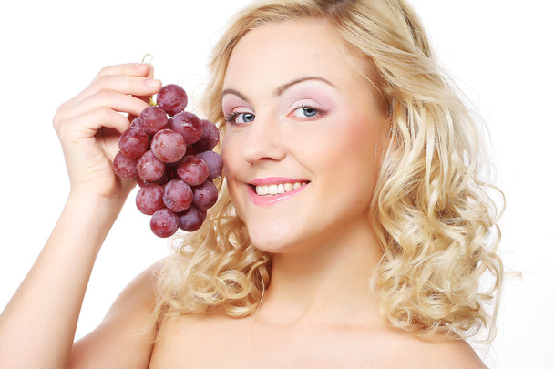 Young woman holding bunch of grapes - Fotoğraf, Görsel