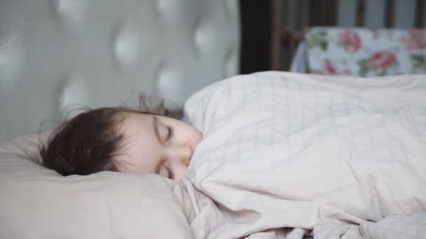 Little cute girl sleeping in a bed in her bedroom. - Filmati, video