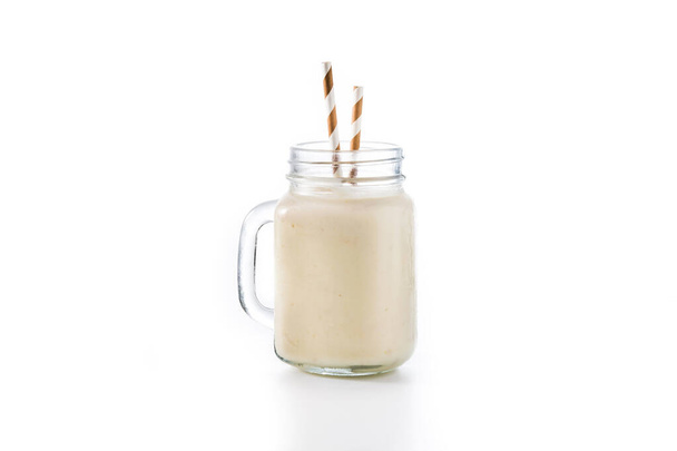 Banaan smoothie met amandel in pot geïsoleerd op witte achtergrond - Foto, afbeelding