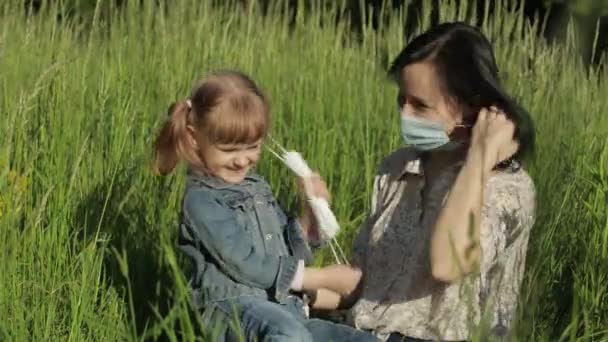 Rodina v parku sundává lékařské masky po ukončení pandemické karantény koronaviru - Záběry, video