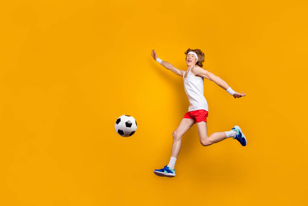 Full length body size view of his he nice funky carefree cheerful cheery glad motivated guy jumping playing soccer having fun isolated over bright vivid shine vibrant yellow color background - Foto, immagini