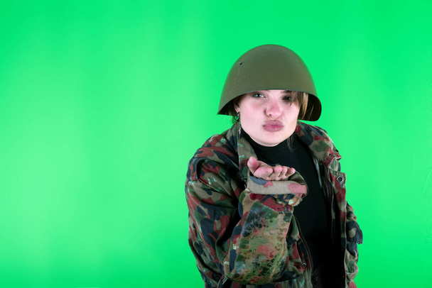 military girl photographed on a green background - Photo, Image