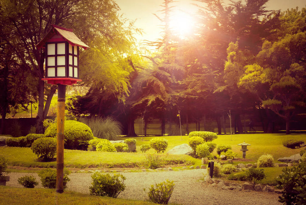 Şili, La Serena 'da günbatımında Japon bahçesinde dekoratif ahşap fener. - Fotoğraf, Görsel