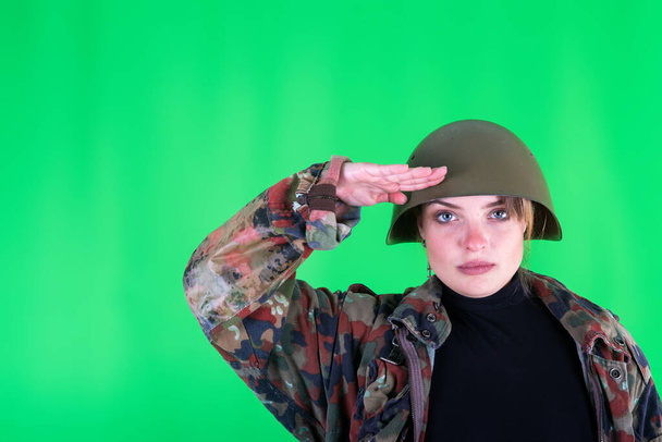 Военная девушка сфотографирована на зеленом фоне
 - Фото, изображение