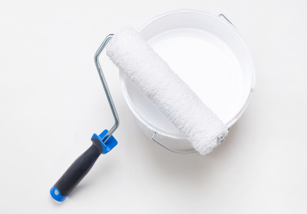 Házjavítás, görgő egy vödör fehér festék - Fotó, kép