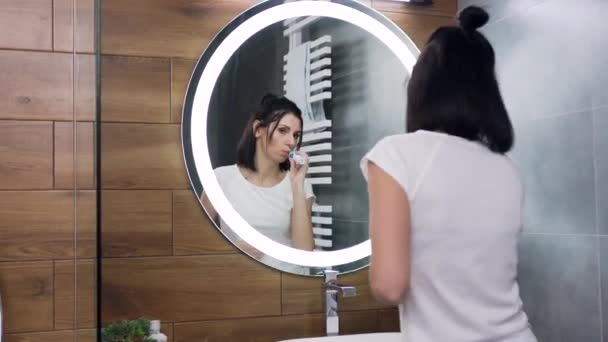Rallentatore di felice attraente giovane donna dai capelli neri che danza davanti allo specchio del bagno durante il lavaggio dei denti
 - Filmati, video