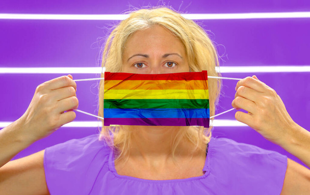 Mujer con bandera de arco iris máscara quirúrgica
 - Foto, imagen