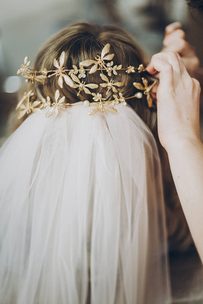 Stilvolles Haar, stilvolles Braut-Diadem mit Schmetterlingen, morgendliche Vorbereitungen für den Hochzeitstag. Braut im Friseursalon Styling ihrer Haare mit modernen authentischen Kranz und Schleier - Foto, Bild