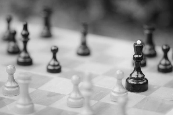 Black and white pieces on a wooden chess Board for playing chess - Photo, Image