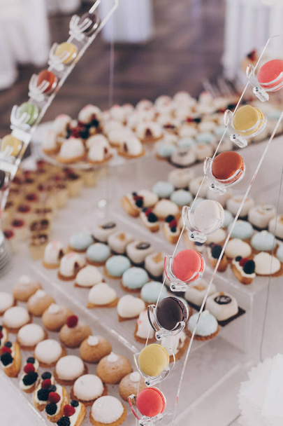 Hochzeitsschokoriegel. Köstliche cremige Desserts mit Früchten, Macarons, Kuchen und Plätzchen auf dem Tisch bei der Hochzeitsfeier im Restaurant. Luxus-Catering. - Foto, Bild