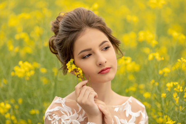 romántico retrato de joven hermosa adolescente en el campo con flores de colza amarilla. pureza e inocencia
 - Foto, imagen