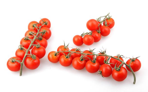 Tomates cerises biologiques fraîches isolées sur fond blanc. La tomate cerise est considérée comme une variété botanique de la baie cultivée, Solanum lycopersicum var. cérasiforme
 - Photo, image