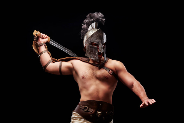 Gladiator with sword and armor on a black background - Photo, Image